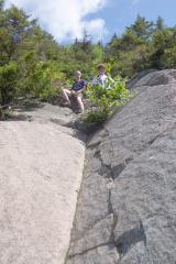 cleft rock dihedral in the mountainside, with Phil and Kevin seated near the top