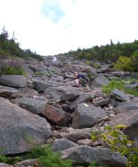 Phil hiking up steep, open boulder slide