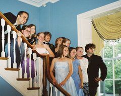 The bride and groom and ten of their young pose on the stairwell.