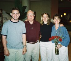 Mark, Grandpa, Heidi, and Nancy; Nancy is holding a vase of red roses.