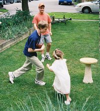 Hannah chases Phil who's carrying a football.