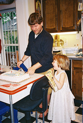 Steve and Hannah laugh as the first piece of cake is cut.