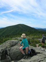 Jocelyn in blue fleece and cute hat, with her head turned away toward a mountain in the background
