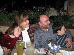 Kimberly, Nancy, Dave, and Andy seated at a restaurant table, all looking to the viewer's right