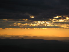 yellow sunset with clouds, above mountain ranges