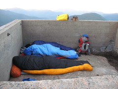 three sleeping bags occupying an old foundation