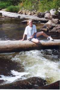 Jocelyn on a log over a stream