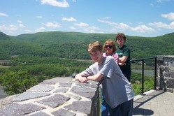 Philip, Kathy, and Kevin at an overlook with green hills in the background
