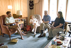 four people seated in the living room