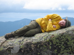 Kevin, in a yellow windbreaker, lying on a rock